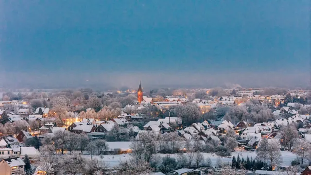 Luftbild von Tostedt zur blauen Stunde, Ortskern mit Kirche im Schnee.